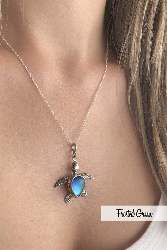 Sideways Sea Turtle Pendant inspired by the Hawaiian Green Turtle, known as Honu. This charming frosted blue pendant features moveable elements for the turtle's head, arms, legs, and tail. The pendant comes with an 18" sterling silver .7mm box chain included.