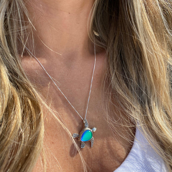 Sideways Sea Turtle Pendant inspired by the Hawaiian Green Turtle, known as Honu. This charming frosted blue pendant features moveable elements for the turtle's head, arms, legs, and tail. The pendant comes with an 18" sterling silver .7mm box chain included.