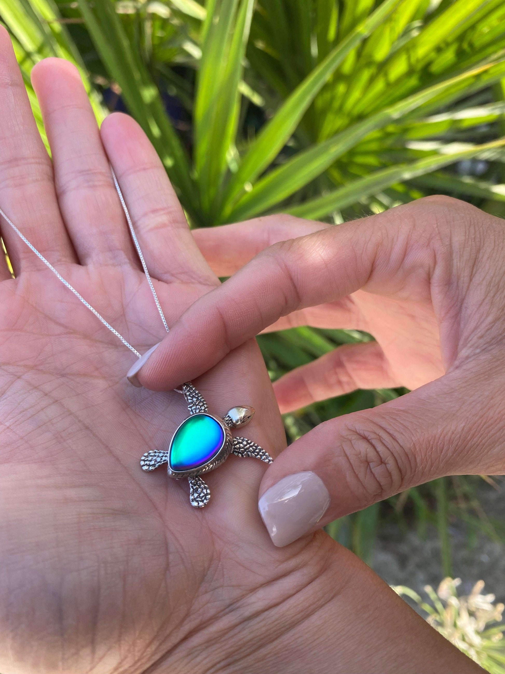 Sideways Sea Turtle Pendant inspired by the Hawaiian Green Turtle, known as Honu. This charming frosted blue pendant features moveable elements for the turtle's head, arms, legs, and tail. The pendant comes with an 18" sterling silver .7mm box chain included.