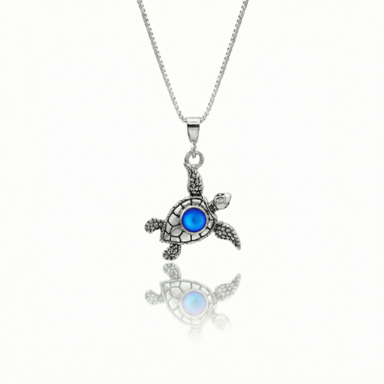 Small Turtle Pendant featuring a charming design, this pendant is adorned with a 5mm frosted blue stone that adds a touch of sparkle. It comes with an 18" .7mm sterling silver box chain, ensuring it’s ready to wear right away.