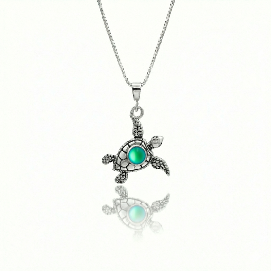 Small Turtle Pendant featuring a charming design, this pendant is adorned with a 5mm frosted green stone that adds a touch of sparkle. It comes with an 18" .7mm sterling silver box chain, ensuring it’s ready to wear right away.