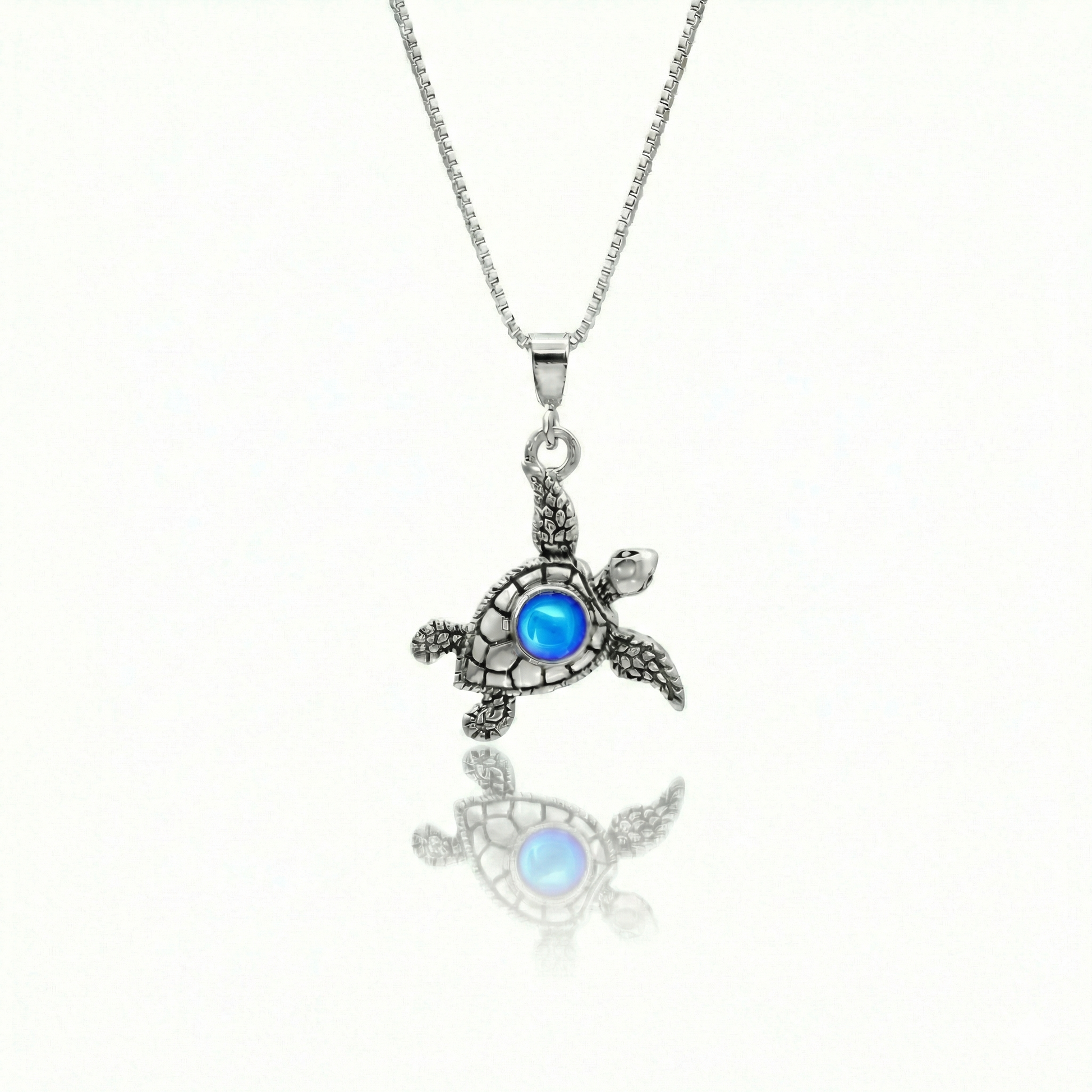 Small Turtle Pendant featuring a charming design, this pendant is adorned with a 5mm polished blue stone that adds a touch of sparkle. It comes with an 18" .7mm sterling silver box chain, ensuring it’s ready to wear right away.