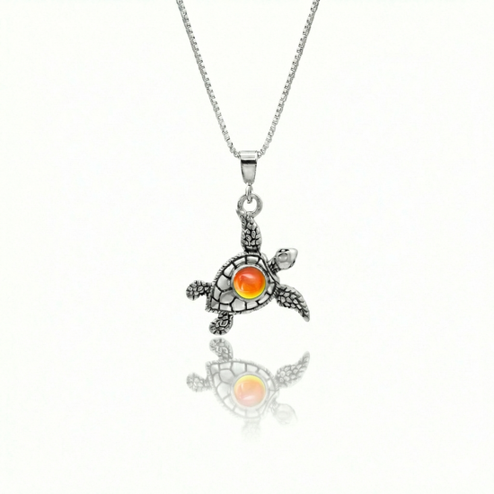 Small Turtle Pendant featuring a charming design, this pendant is adorned with a 5mm polished fire stone that adds a touch of sparkle. It comes with an 18" .7mm sterling silver box chain, ensuring it’s ready to wear right away.
