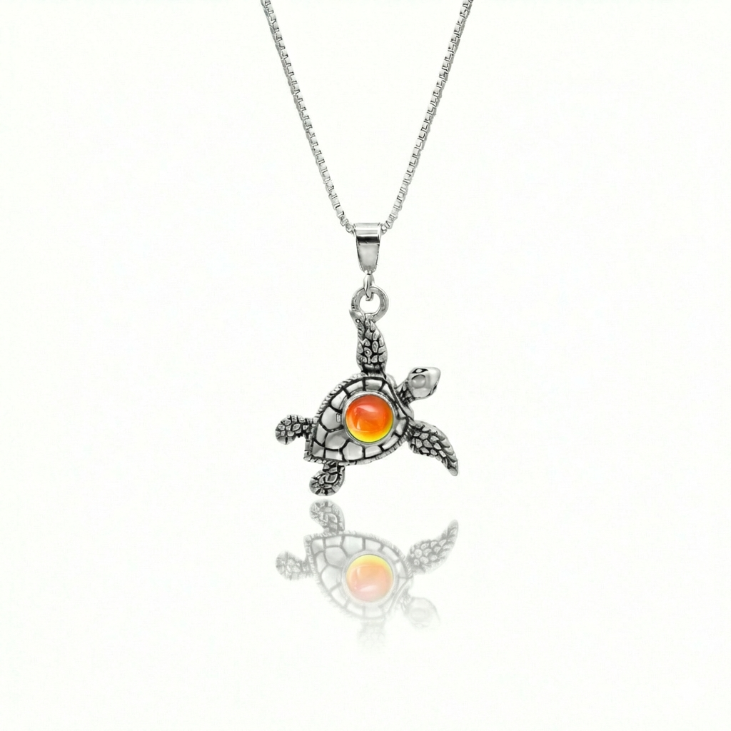 Small Turtle Pendant featuring a charming design, this pendant is adorned with a 5mm polished fire stone that adds a touch of sparkle. It comes with an 18" .7mm sterling silver box chain, ensuring it’s ready to wear right away.