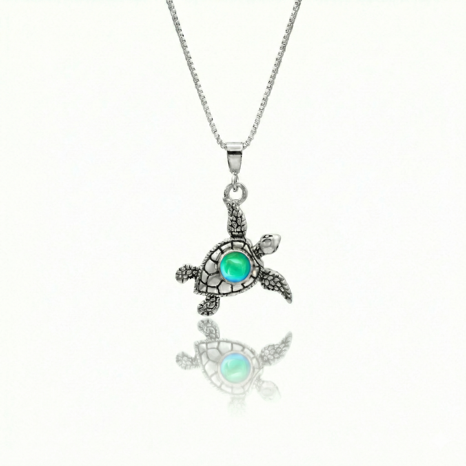 Small Turtle Pendant featuring a charming design, this pendant is adorned with a 5mm polished green stone that adds a touch of sparkle. It comes with an 18" .7mm sterling silver box chain, ensuring it’s ready to wear right away.