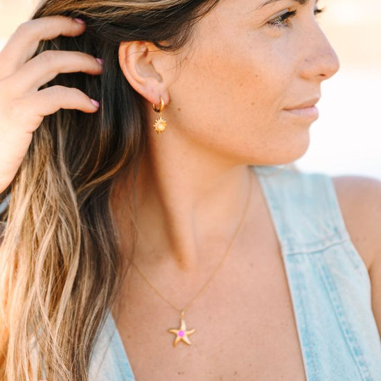 Sunburst Crystal Earrings, a dazzling pair that radiates elegance and brilliance. Inspired by the radiant energy of the sun, these earrings feature a central crystal surrounded by smaller crystals, creating a stunning sunburst effect that catches the light from every angle.