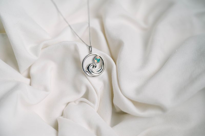 The flowing wave design captures the essence of coastal living in wearable form, making it an ideal gift for anyone who dreams of sandy shores and salty air. 