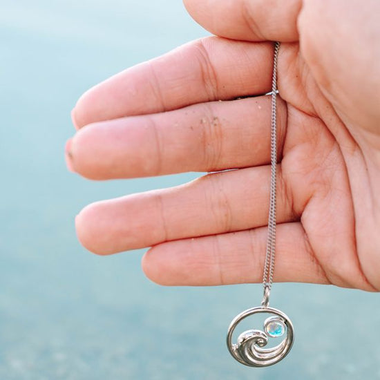 Suspended from an adjustable 16"-18" chain, it sits perfectly at your desired length. Whether you're a surfer, beach enthusiast, or simply drawn to nautical vibes, this pendant brings a splash of maritime charm to your everyday look.
