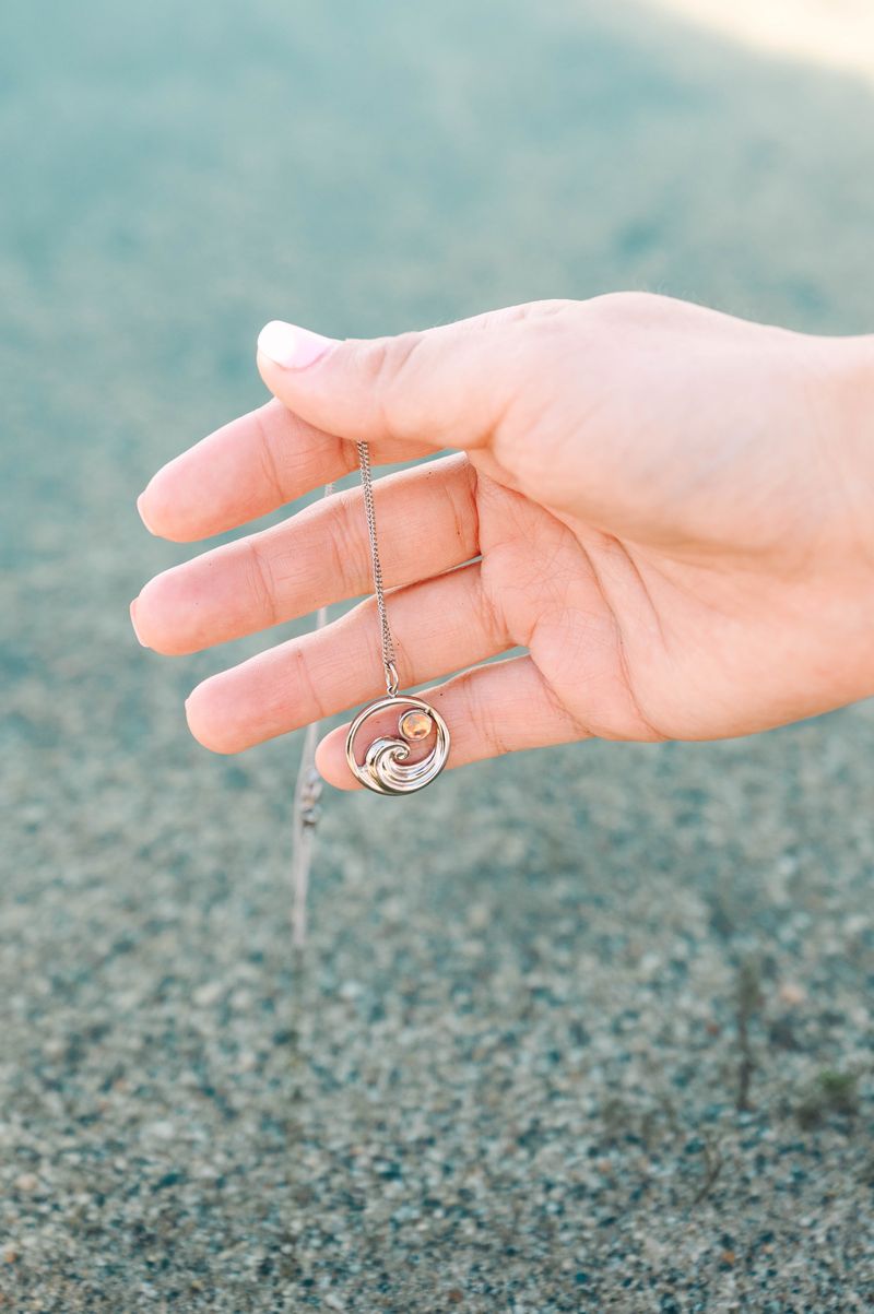 Suspended from an adjustable 16"-18" chain, it sits perfectly at your desired length. Whether you're a surfer, beach enthusiast, or simply drawn to nautical vibes, this pendant brings a splash of maritime charm to your everyday look.