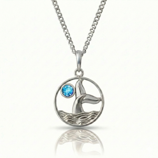 Whale tale pendant with silver stainless steel and a blue gemstone.