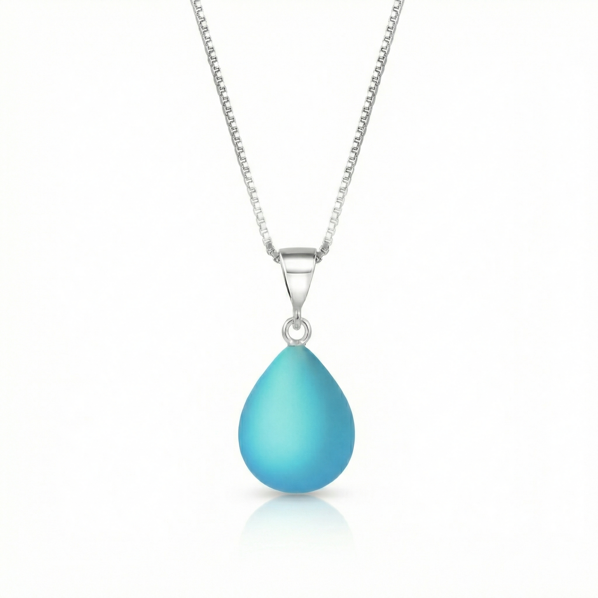 Our best selling crystal X-Small Drop Pendant is a beautiful, easy simple addition to any outfit. Handmade pendants come in a wide variety of colors and shine with an iridescent glow of color from within. Sterling silver .7mm box chain, 18" included with the frosted aqua pendant.