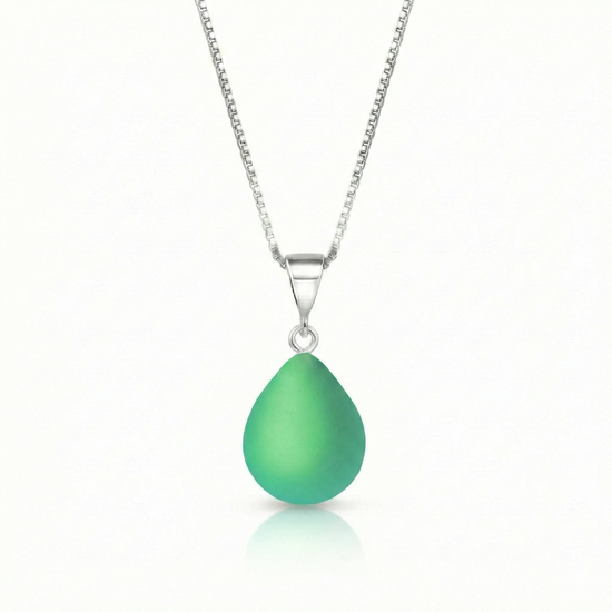 Our best selling crystal X-Small Drop Pendant is a beautiful, easy simple addition to any outfit. Handmade pendants come in a wide variety of colors and shine with an iridescent glow of color from within. Sterling silver .7mm box chain, 18" included with the frosted green pendant.