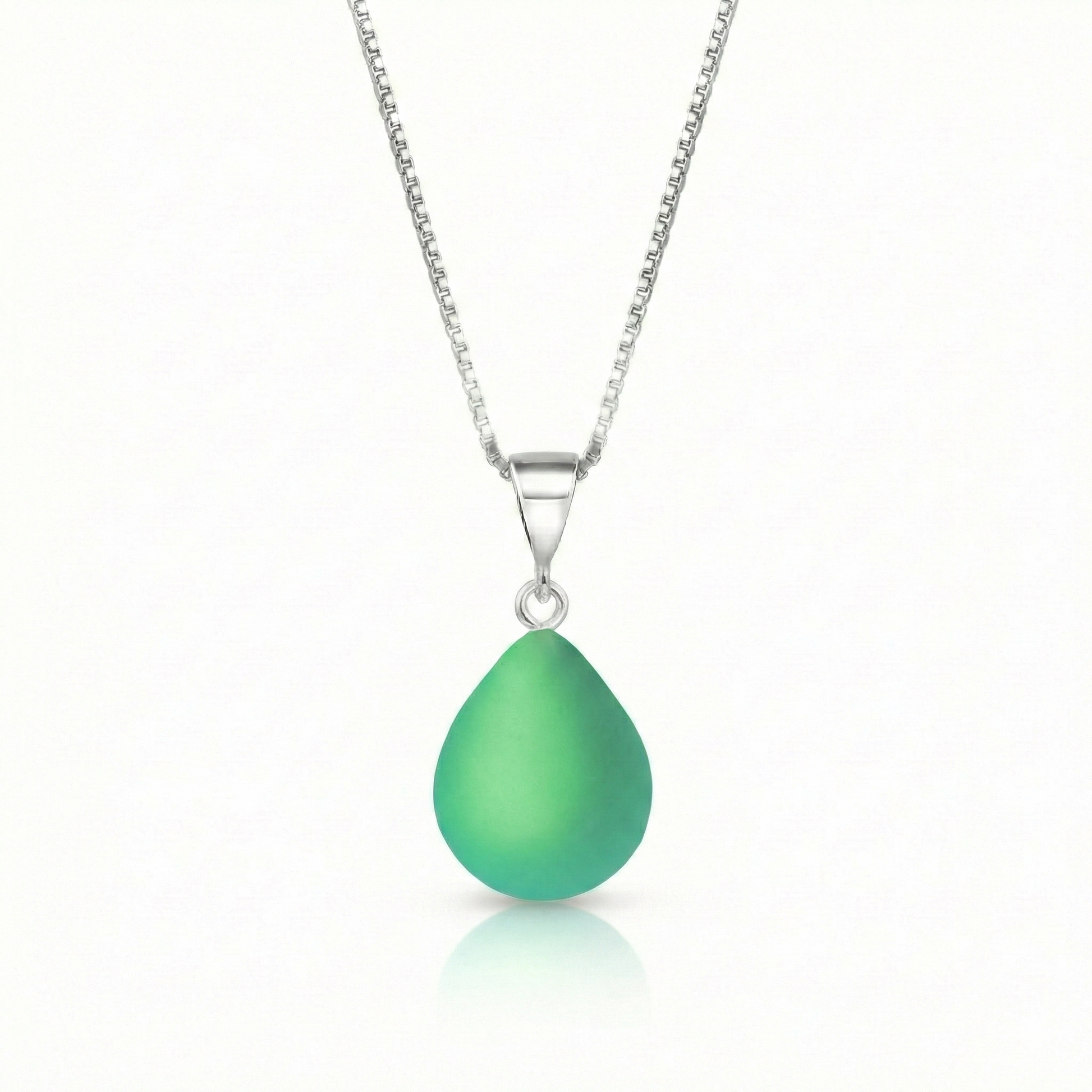 Our best selling crystal X-Small Drop Pendant is a beautiful, easy simple addition to any outfit. Handmade pendants come in a wide variety of colors and shine with an iridescent glow of color from within. Sterling silver .7mm box chain, 18" included with the frosted green pendant.