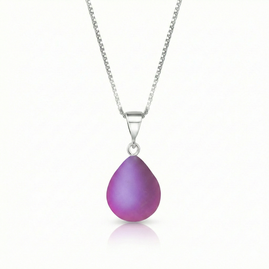 Our best selling crystal X-Small Drop Pendant is a beautiful, easy simple addition to any outfit. Handmade pendants come in a wide variety of colors and shine with an iridescent glow of color from within. Sterling silver .7mm box chain, 18" included with the frosted pink pendant.