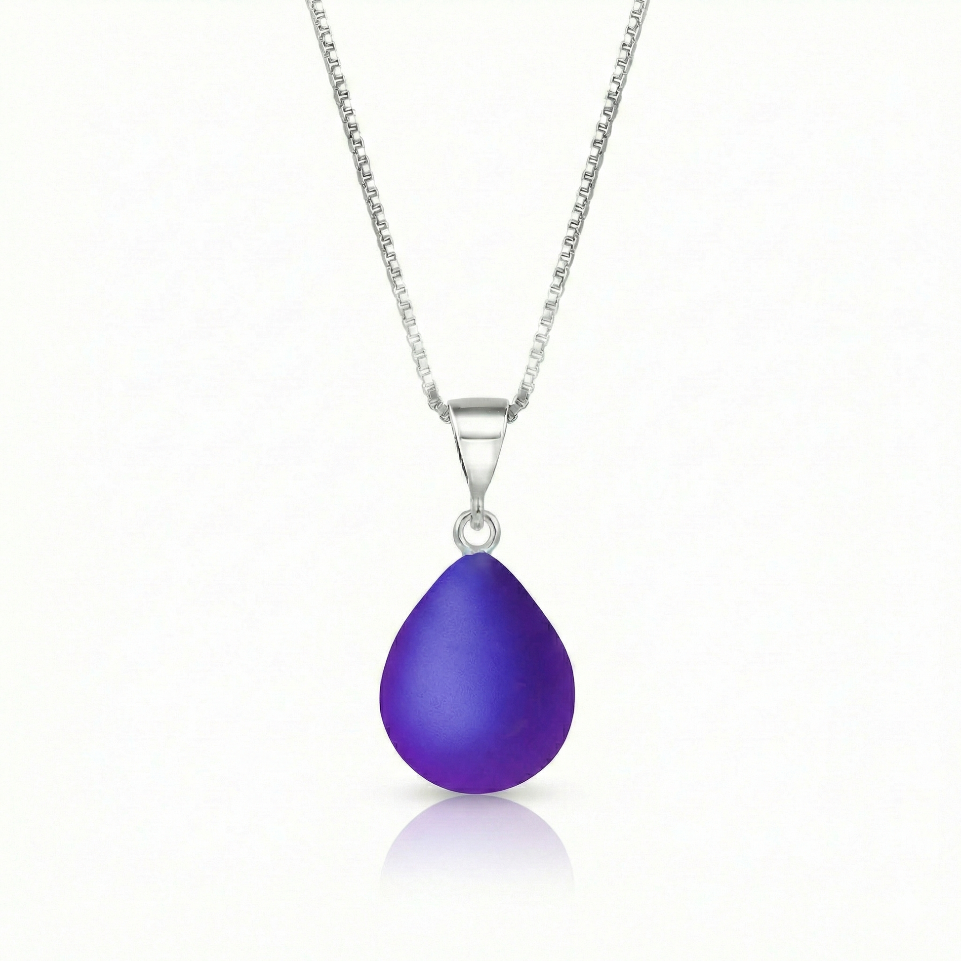 Our best selling crystal X-Small Drop Pendant is a beautiful, easy simple addition to any outfit. Handmade pendants come in a wide variety of colors and shine with an iridescent glow of color from within. Sterling silver .7mm box chain, 18" included with the frosted violet pendant.