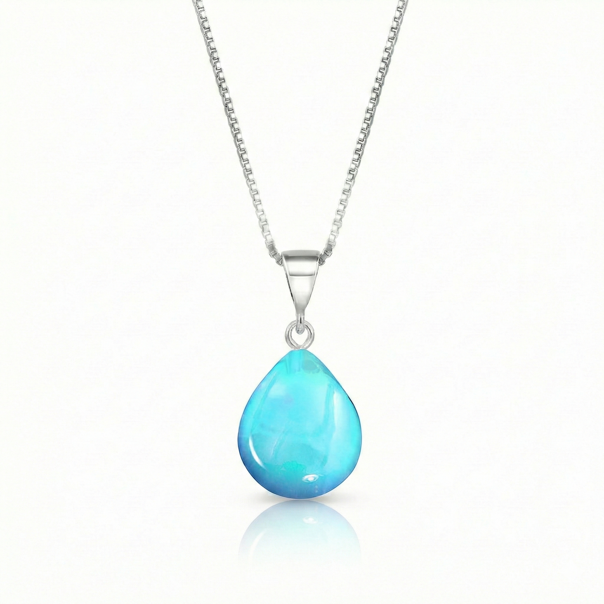 Our best selling crystal X-Small Drop Pendant is a beautiful, easy simple addition to any outfit. Handmade pendants come in a wide variety of colors and shine with an iridescent glow of color from within. Sterling silver .7mm box chain, 18" included with the polished aqua pendant.