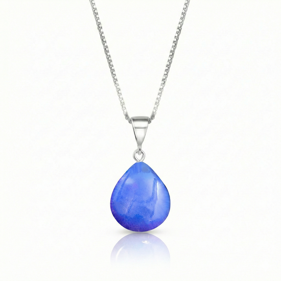 Our best selling crystal X-Small Drop Pendant is a beautiful, easy simple addition to any outfit. Handmade pendants come in a wide variety of colors and shine with an iridescent glow of color from within. Sterling silver .7mm box chain, 18" included with the polished blue pendant.