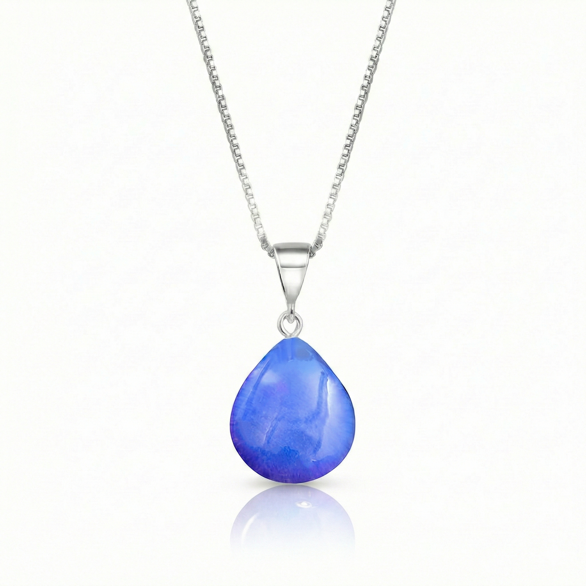 Our best selling crystal X-Small Drop Pendant is a beautiful, easy simple addition to any outfit. Handmade pendants come in a wide variety of colors and shine with an iridescent glow of color from within. Sterling silver .7mm box chain, 18" included with the polished blue pendant.